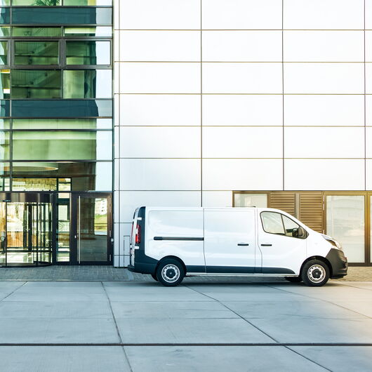 Ein weißer Lieferwagen steht vor einem Gebäude