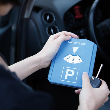 Eine Frau stellt ihre Parkscheibe ein