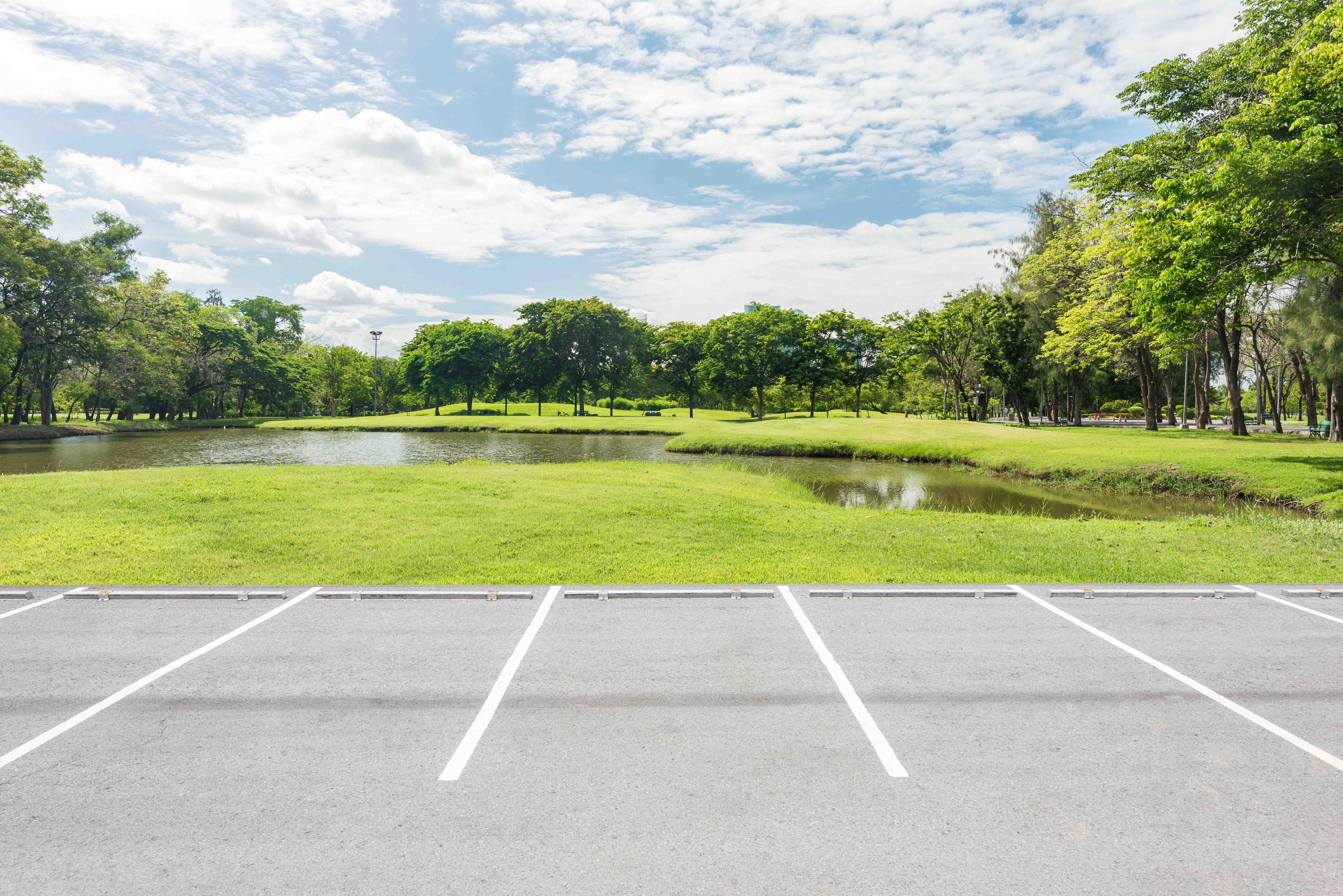Freie Parkplätze vor einem Park mit See